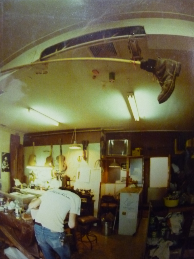 Romney Godden at work 1982 with 'the boot' hanging precariously above. The boot was made by Rommo and Greg and was inspired by similar whacky things in Bugs Bunny cartoons. Yes, it did get used on a few choice occasions when mistakes were made...